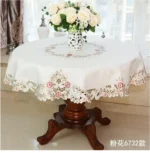 Elegant lace tablecloth with rose gold embroidery on a dining table