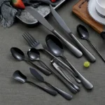 Elegant black stainless steel flatware set with mirror finish on a dining table