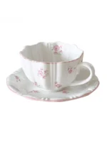 Pink cherry blossom mug with saucer on a dining table