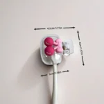 Cherry toothbrush holder on a wooden bathroom shelf with other accessories.