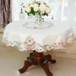 Elegant lace tablecloth with rose gold embroidery on a dining table