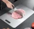 Double thick titanium cutting board with juice groove on a kitchen countertop