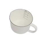 Enamel baking measuring cup with dual scale markings on a kitchen counter