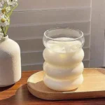 Set of glass cups with straws on a wooden table, filled with iced tea and lemon