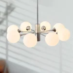 Chandelier in a bedroom, casting gentle light over a bed with neutral bedding.