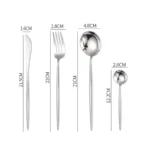 Elegant stainless steel flatware set with forks, spoons, and knives arranged on a wooden table