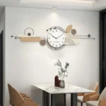 Modern non-ticking wall clock with silver metal frame hanging above a wooden dining table.