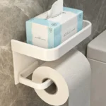 Toilet paper holder mounted beside toilet, showcasing slim profile and shelf for phone.