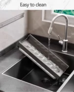 Stainless steel wall mounted dish rack holding plates and bowls in a modern kitchen