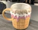 Cute donut ceramic coffee mug on a desk with cozy decor