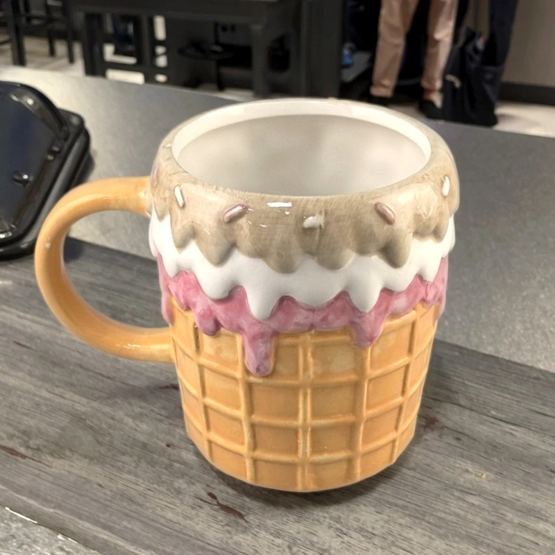 Cute donut ceramic coffee mug on a desk with cozy decor