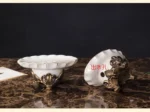 Vintage-style toothbrush holder with an ornate base, on a marble bathroom counter.