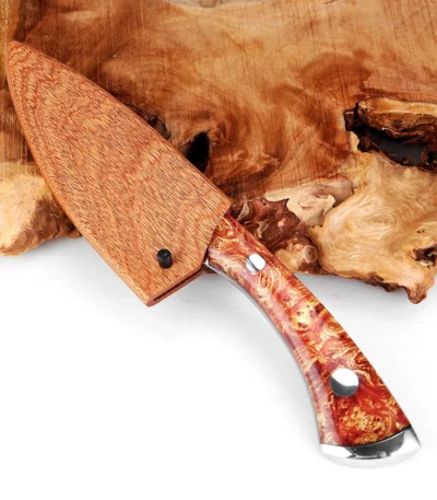 Damascus steel cleaver with wooden sheath on cutting board