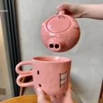 Funny pig teapot pouring tea from its snout on a kitchen counter