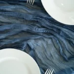 Rustic cheesecloth table runner on wooden table with boho decor