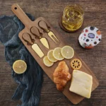Acacia cheese board set with cheese knives and wooden cutting board on a table