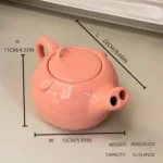 Funny pig teapot pouring tea from its snout on a kitchen counter
