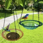 Bird bath plate with water, hanging from a tree, surrounded by green leaves and branches.