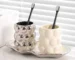 Luxury electroplated ceramic mug set for couples, two toothbrush cups in metallic finish on bathroom counter.