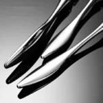 Elegant French stainless steel cutlery set with pointed tail handles on a wooden table