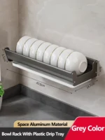 Stainless steel wall mounted dish rack holding plates and bowls in a modern kitchen