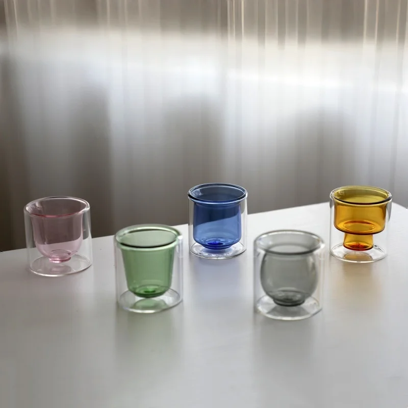 Clear double wall insulated glass mug with espresso coffee on wooden table