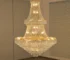 Modern crystal chandelier for dining room hanging over a wooden table with warm glow