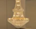 Modern crystal chandelier for dining room hanging over a wooden table with warm glow