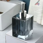 Glass soap dispenser with silver pump, angled shot.