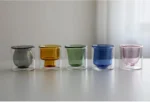 Clear double wall insulated glass mug with espresso coffee on wooden table