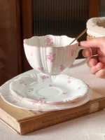 Pink cherry blossom mug with saucer on a dining table