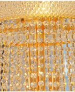 Modern crystal chandelier for dining room hanging over a wooden table with warm glow