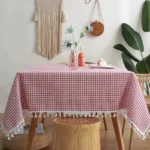 Cotton linen tablecloth with pastoral lattice pattern, lace trim, and tassels on a dining table