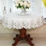 Elegant lace tablecloth with rose gold embroidery on a dining table