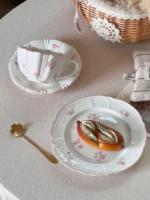 Pink cherry blossom mug with saucer on a dining table