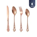 Gold flatware set with spoon, fork, and steak knife on a white tablecloth