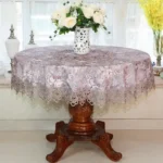 Elegant lace tablecloth with rose gold embroidery on a dining table
