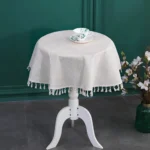 Round linen tablecloth with tassels on a dining table