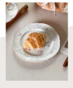 Pink cherry blossom mug with saucer on a dining table