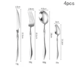 Elegant French stainless steel cutlery set with pointed tail handles on a wooden table