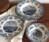 Vintage blue floral dinner set arranged on a wooden table with plates, bowls, and cups