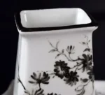 Toothbrush holder and mouthwash cup on a glass shelf, reflecting in the mirror.