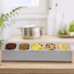 Stainless steel spice rack with 5 pans and lids on kitchen countertop