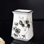 Toothbrush holder with three compartments, each holding a toothbrush, on a mirrored shelf.