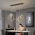 Modern gold dome pendant light hanging over a wooden dining table in a bright room.