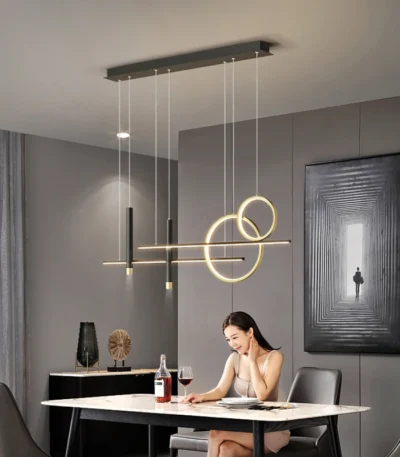 Modern gold dome pendant light hanging over a wooden dining table in a bright room.