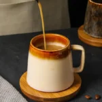 Vintage ceramic coffee mug with underglaze floral pattern on wooden table