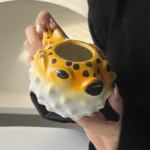 Creative pufferfish tiki mug for cocktails with vibrant hand-painted details on a wooden table