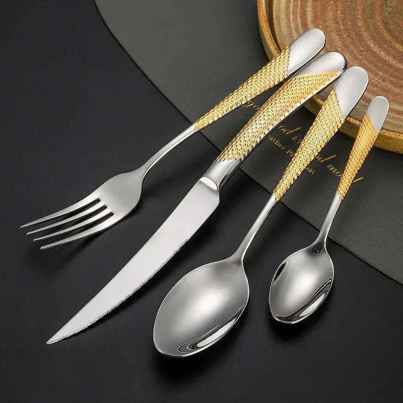 Elegant gold flatware set with steak knife, fork, and spoon on a dark table