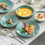 Vancasso KARST green stoneware dinner set with embossed plates and bowls on a rustic wooden table